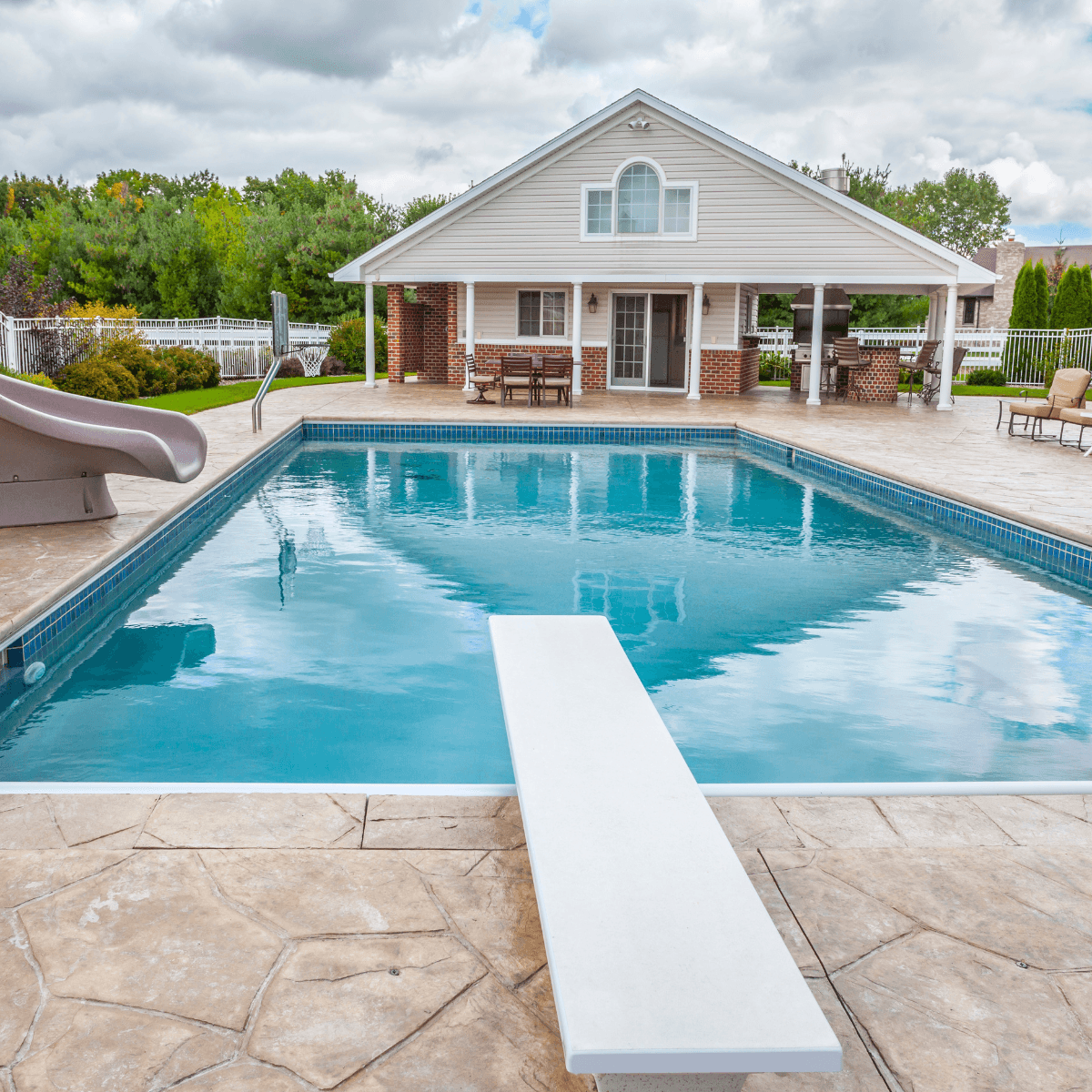 65 custom built pool deck featuring a pool slide and diving board